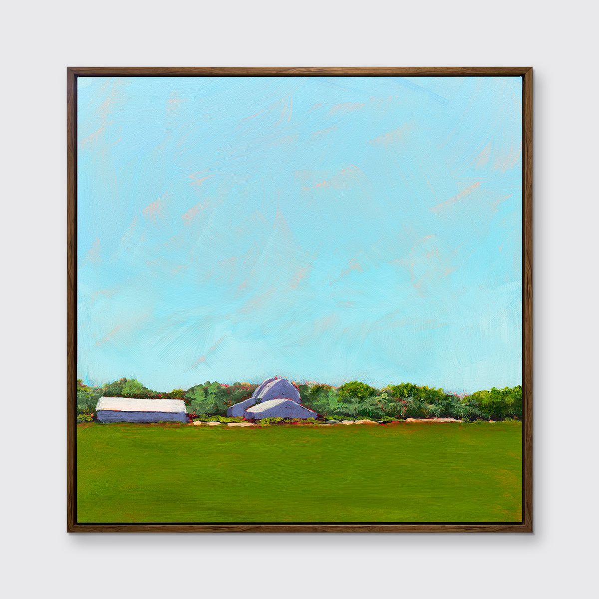 A blue, green, lavender and white landscape print in an oak wood floater frame hangs on a white wall.
