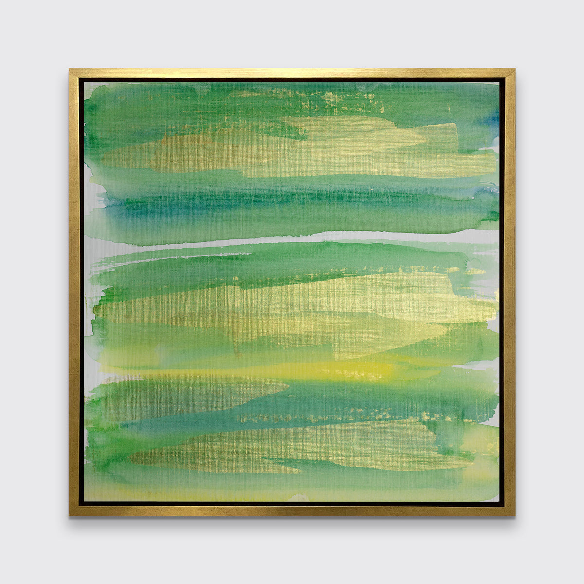 A green, blue and gold abstract print in a gold floater frame hangs on a white wall.