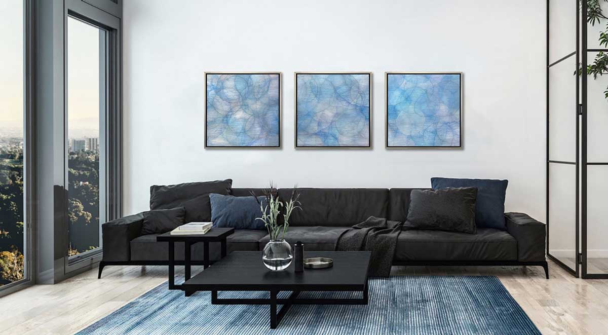 Layers of overlapping circles with an iridescent feel in blues, light purples and light greens, series, staged in silver floater frames in a living room.