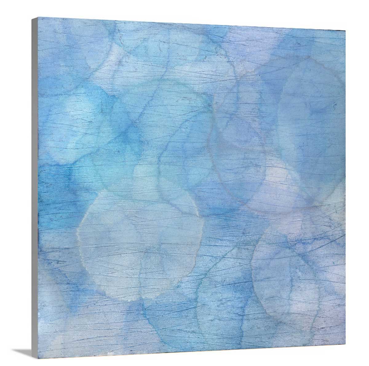 Layers of overlapping circles with an iridescent feel in blues, light purples and light greens staged on a side angle of a canvas.