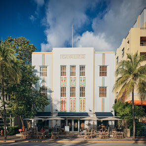 A photograph of art deco buildings in Miami Beach, with palm trees.