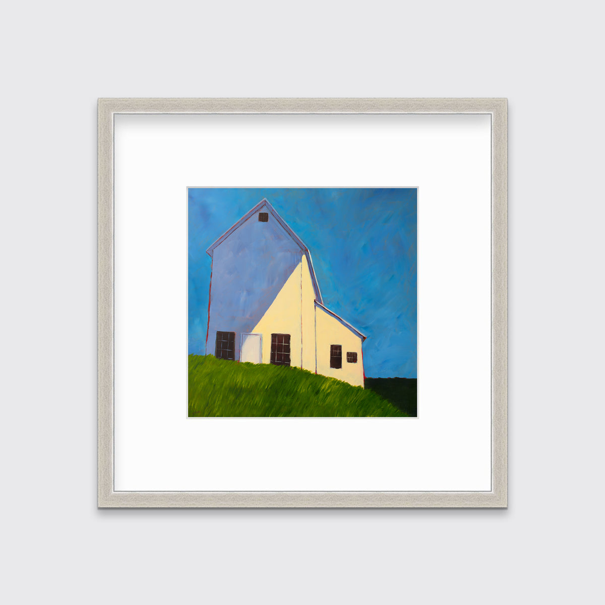 A blue, beige, lavender and green contemporary barn print in a silver frame with a mat hangs on a white wall.