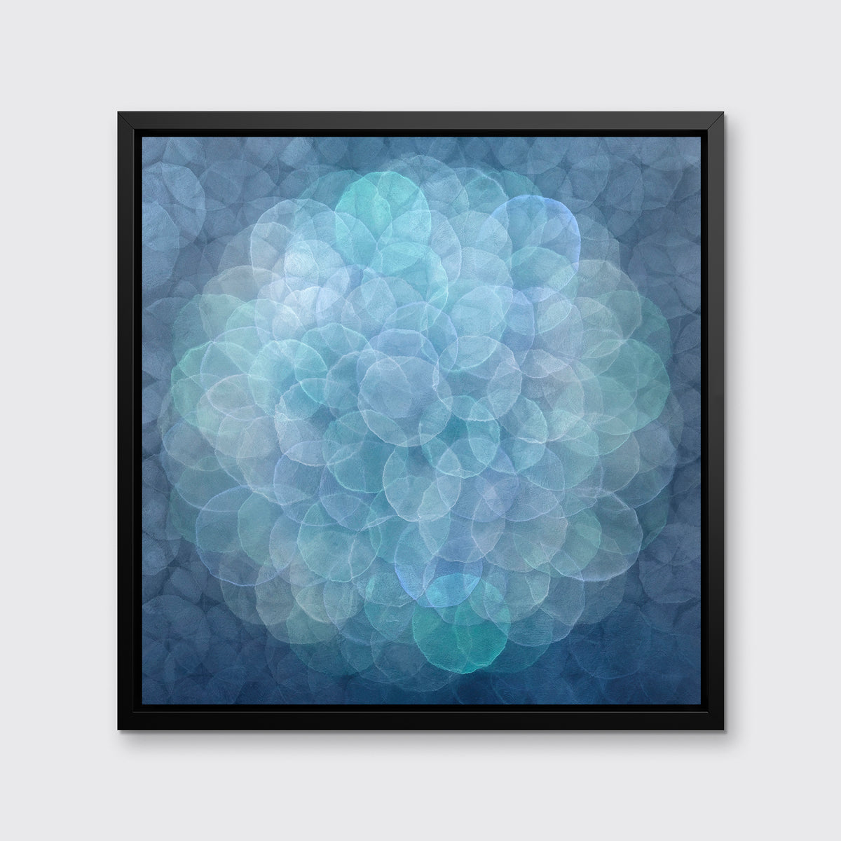 A blue, teal, light lavender and white abstract geometric print in a black floater frame hangs on a white wall.