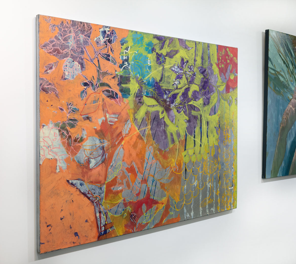 A painting is seen at an angle. Beautiful floral motifs in neon green, purple, orange, and blue adorn the painting. The painting is wired and ready to hang.