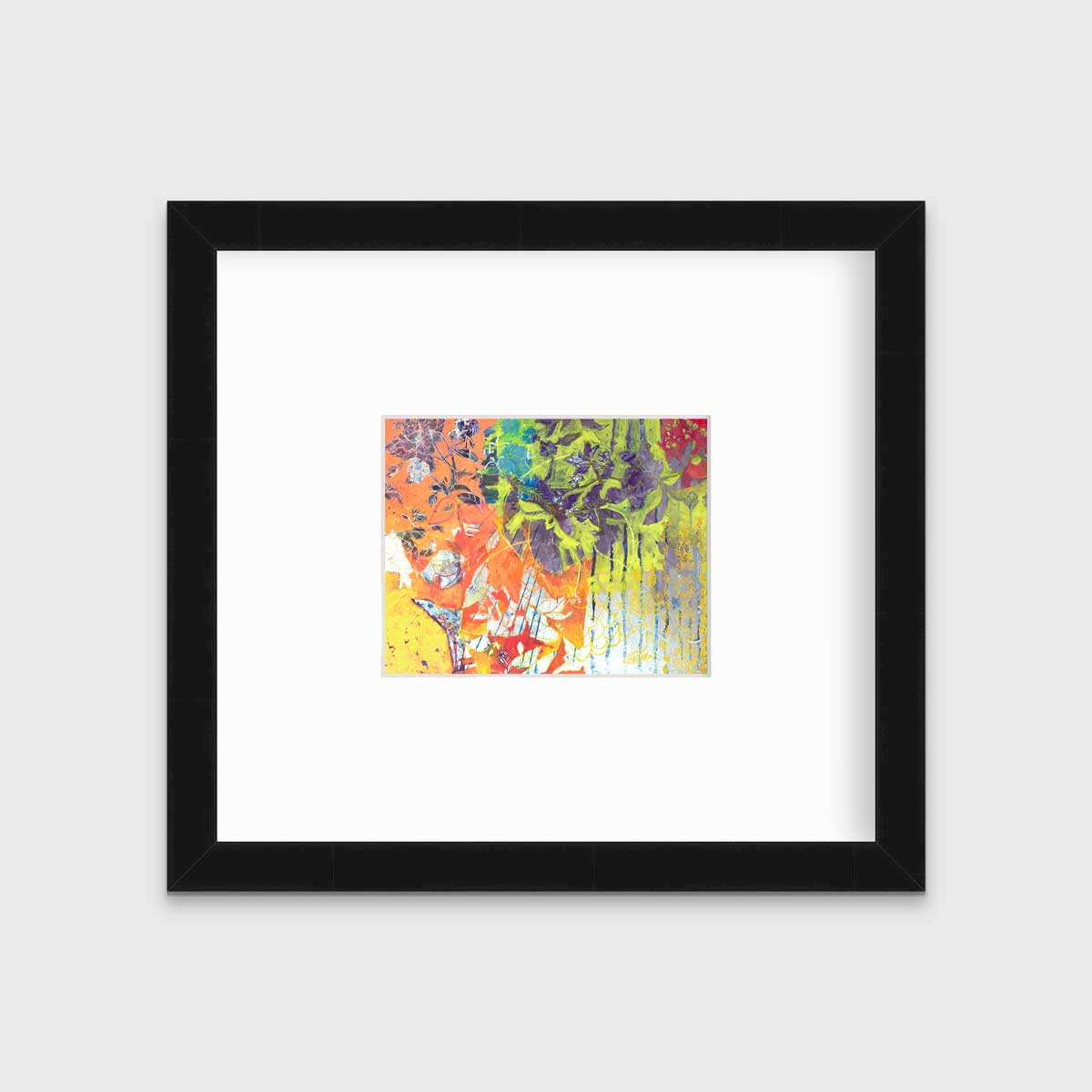 A multicolored abstract print in a black frame with a mat hangs on a white wall.
