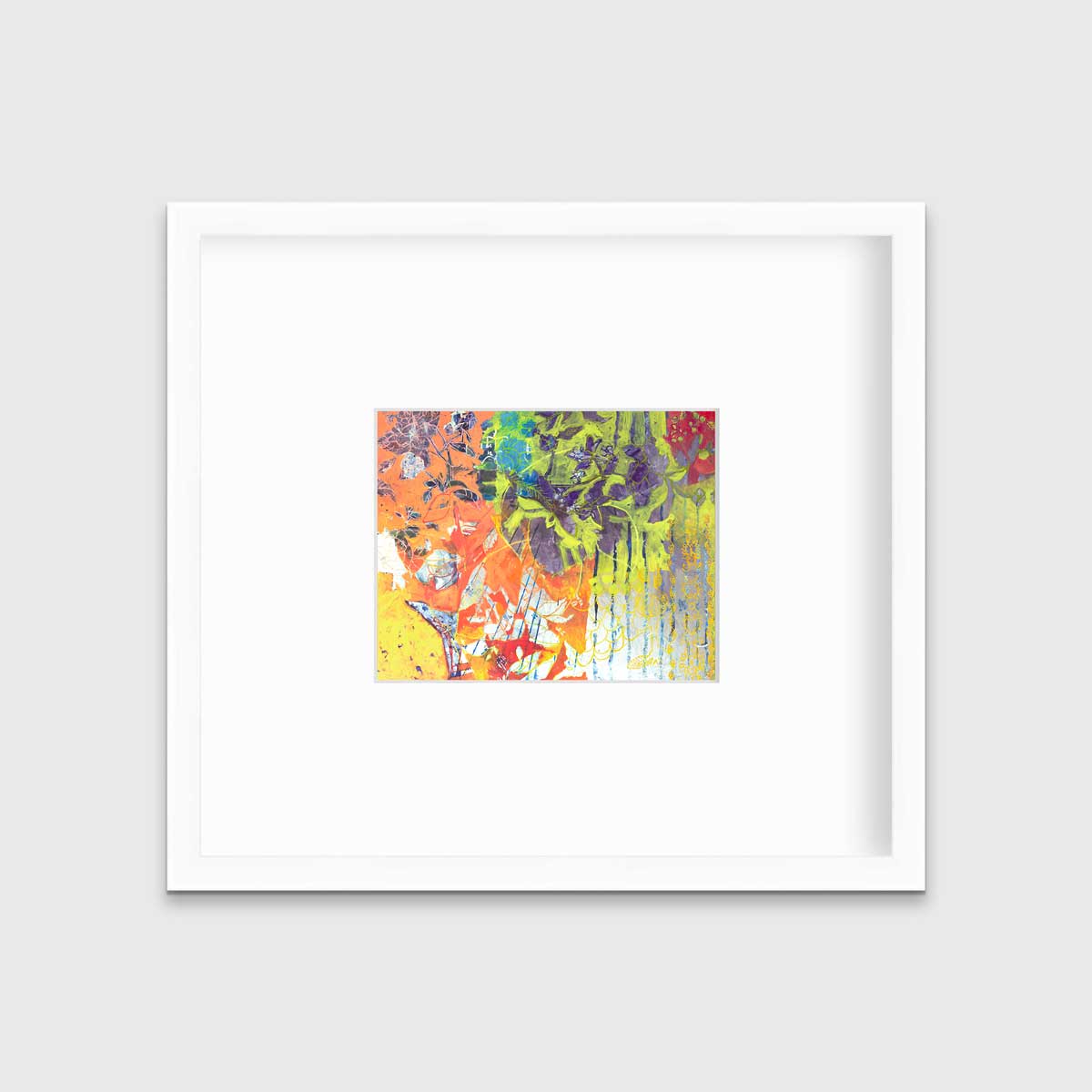 A multicolored abstract print in a white frame with a mat hangs on a white wall.