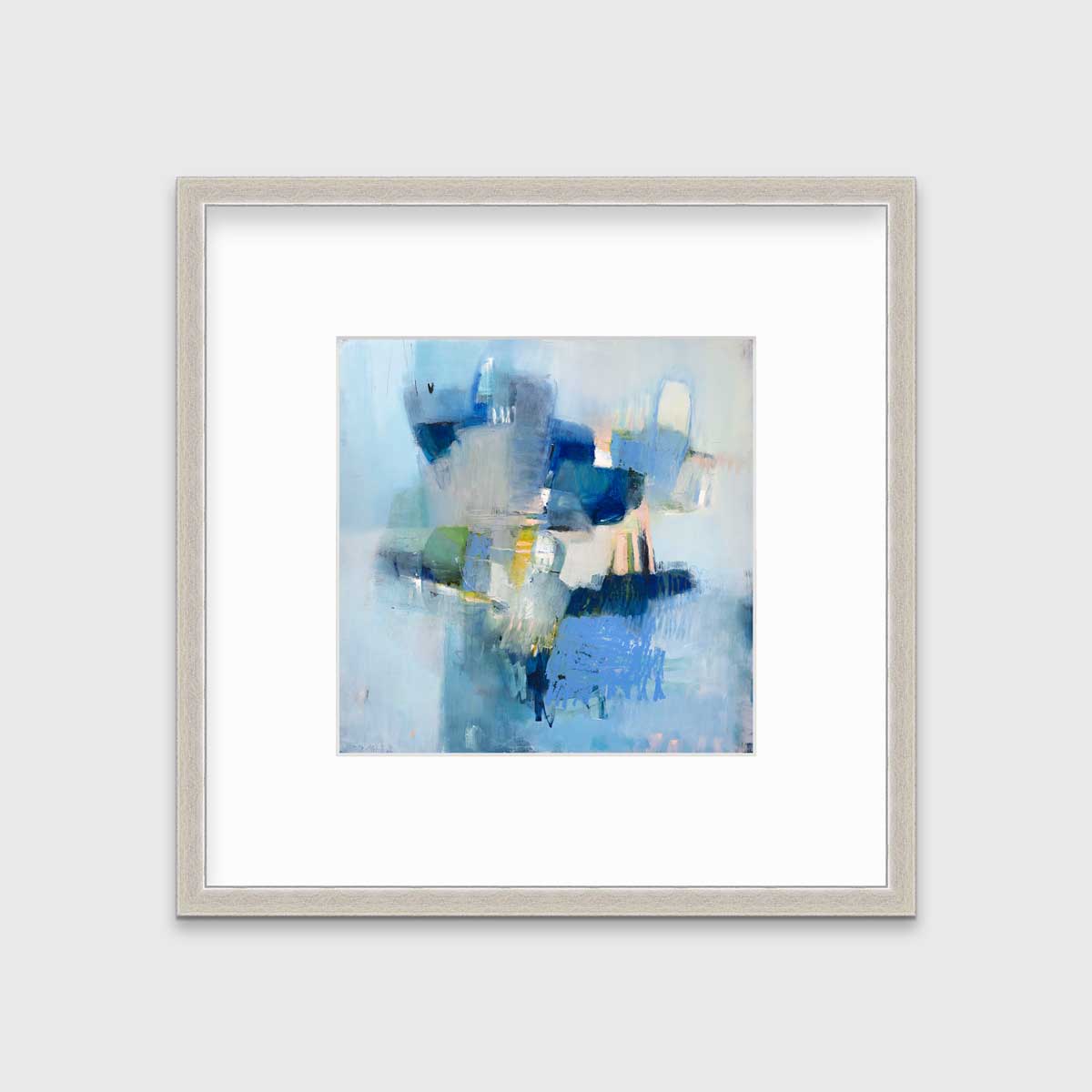 A blue abstract print by Kelly Rossetti in a silver frame with a mat hangs on a white wall.