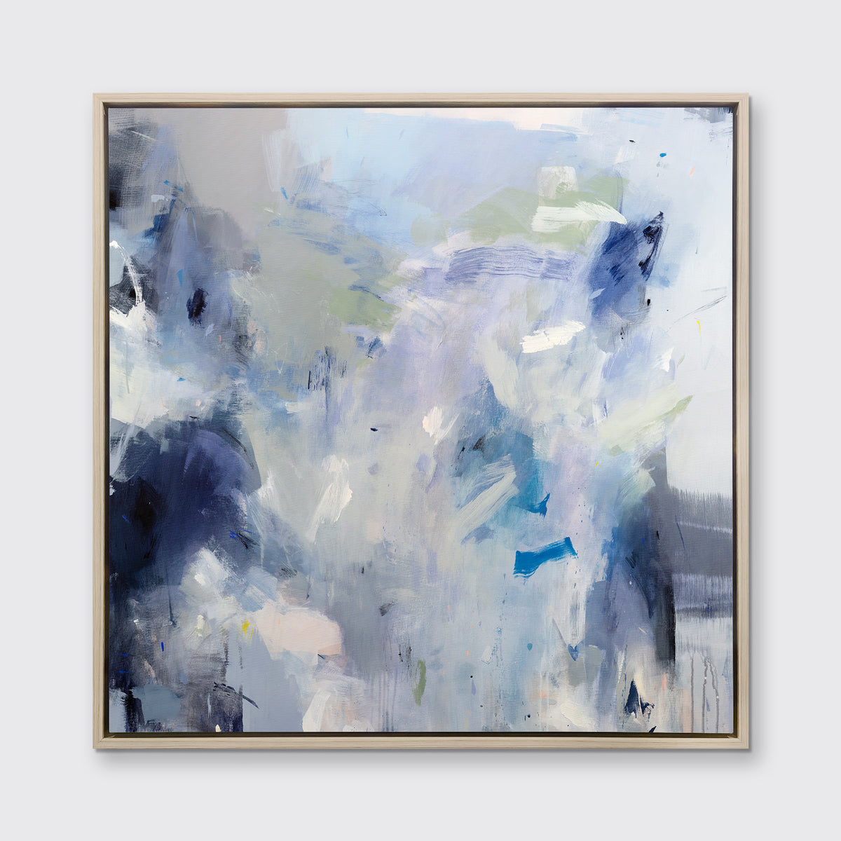 A blue, white, lavender and dark blue abstract print in a white oak wood floater frame hangs on a white wall.