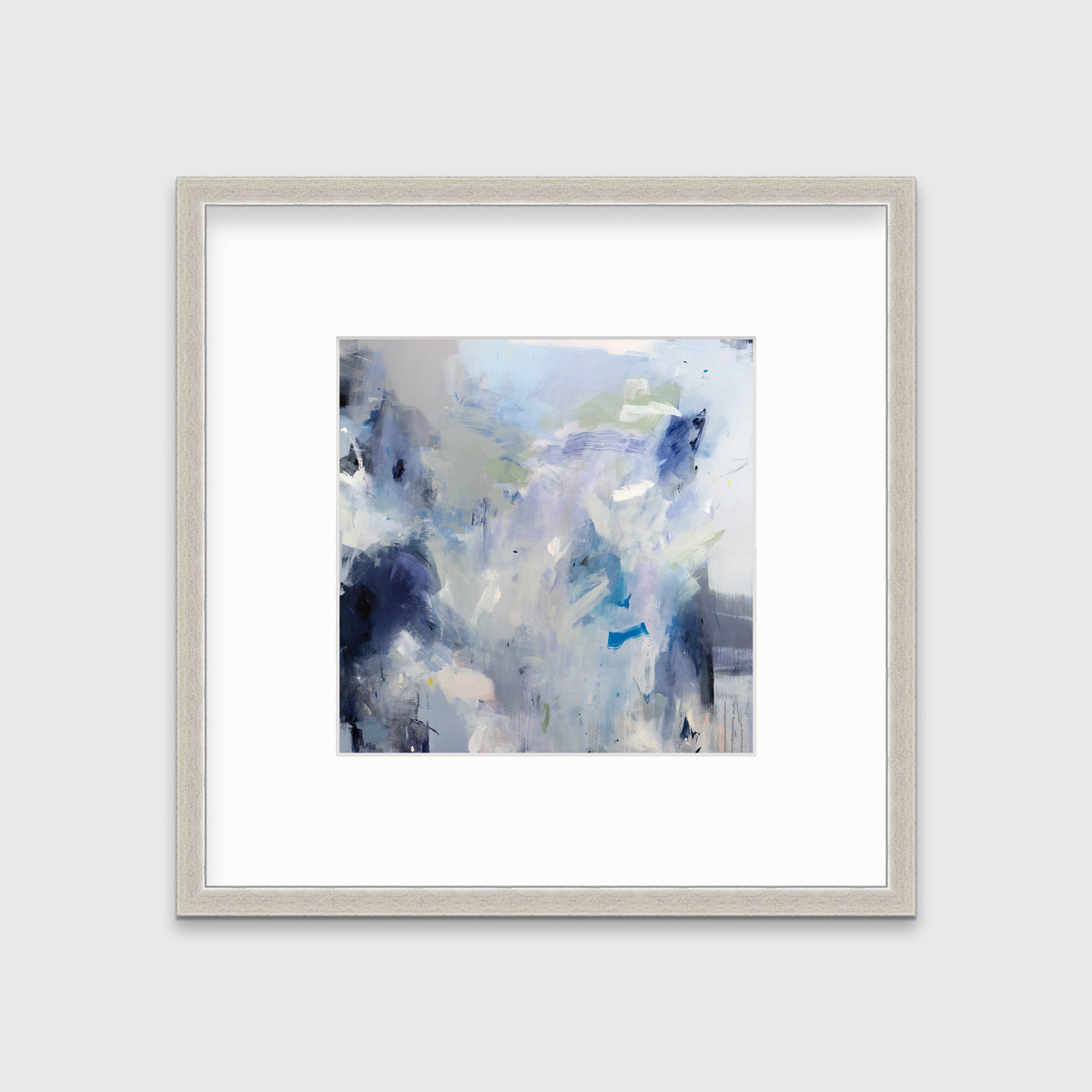 A blue, white, lavender and dark blue abstract print in a silver frame with a mat hangs on a white wall.
