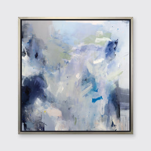 A blue, white, lavender and dark blue abstract print in a silver floater frame hangs on a white wall.