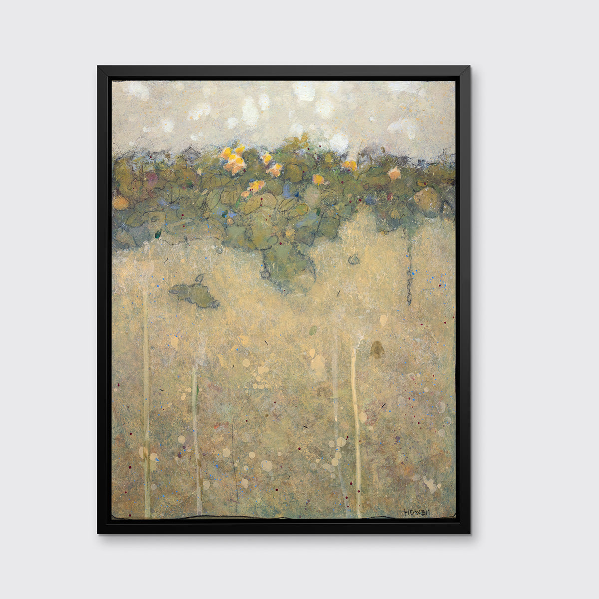 A muted yellow, green and beige abstract landscape print in a black floater frame hangs on a white wall.