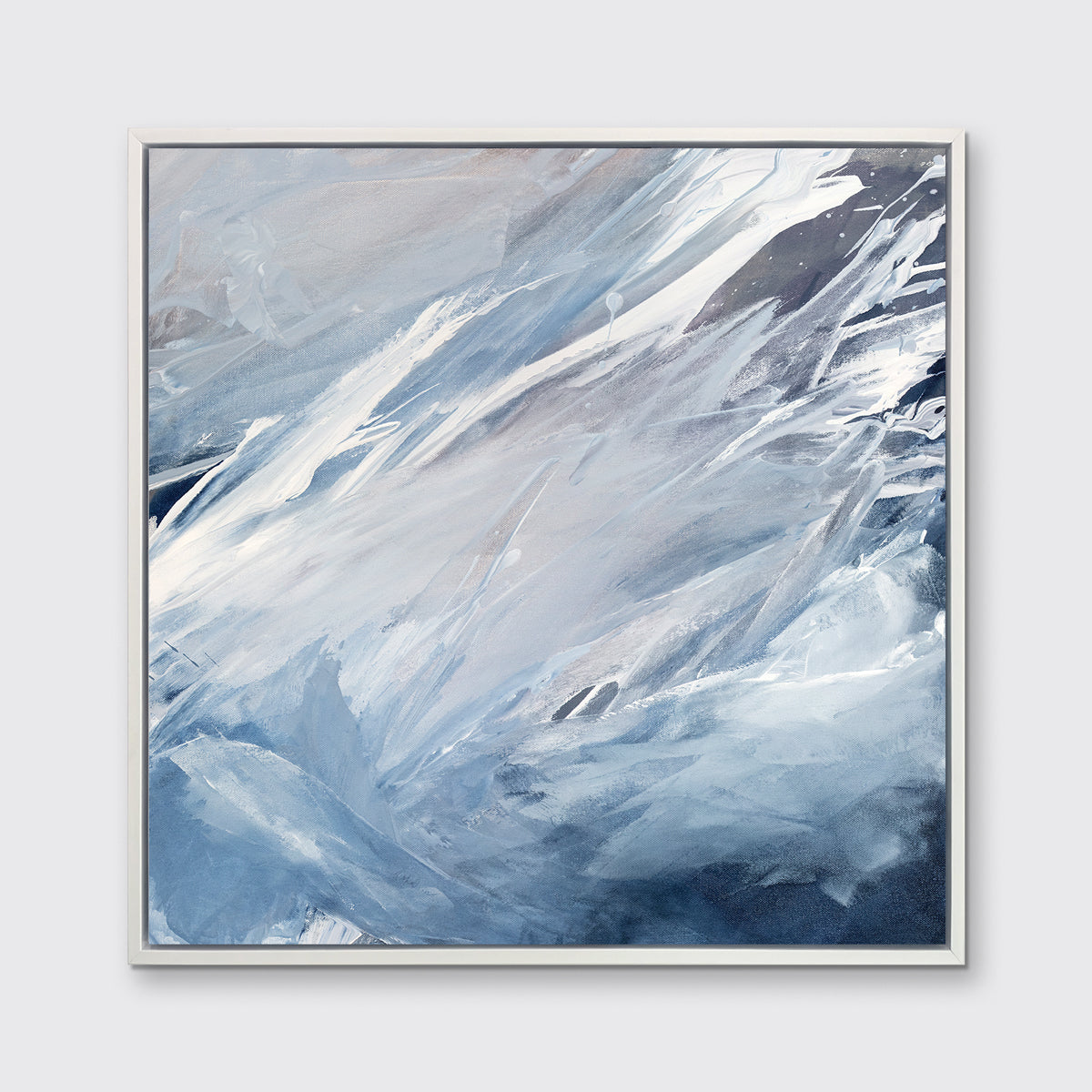 A blue, grey, white and charcoal abstract print in a white floater frame hangs on a white wall.