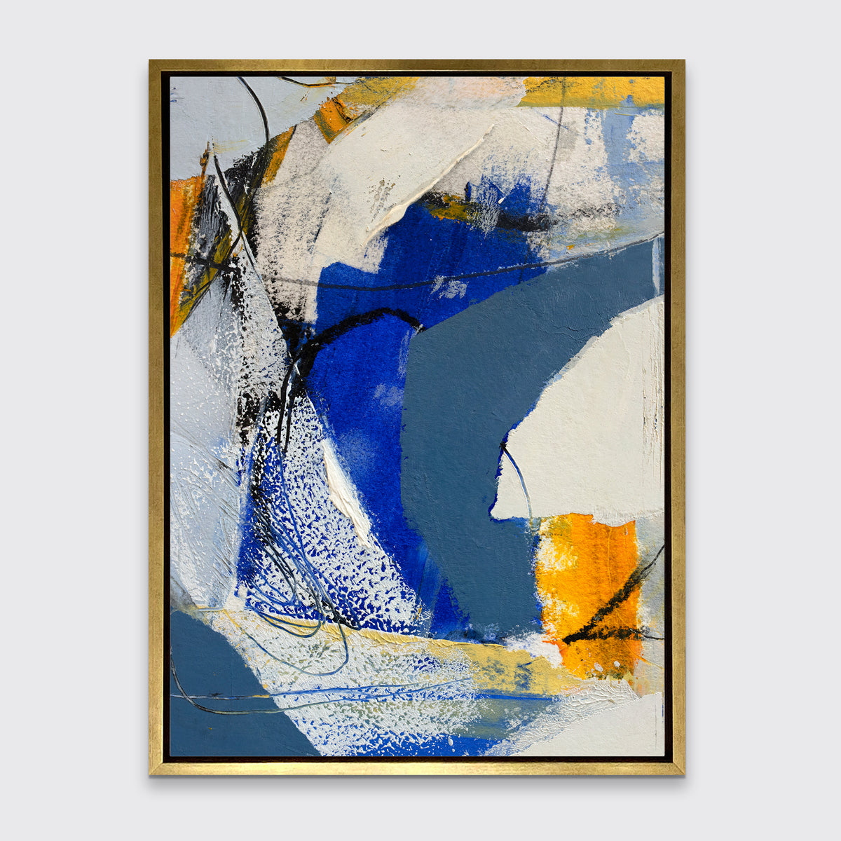 A blue, grey and yellow abstract print in a gold floater frame hangs on a white wall.