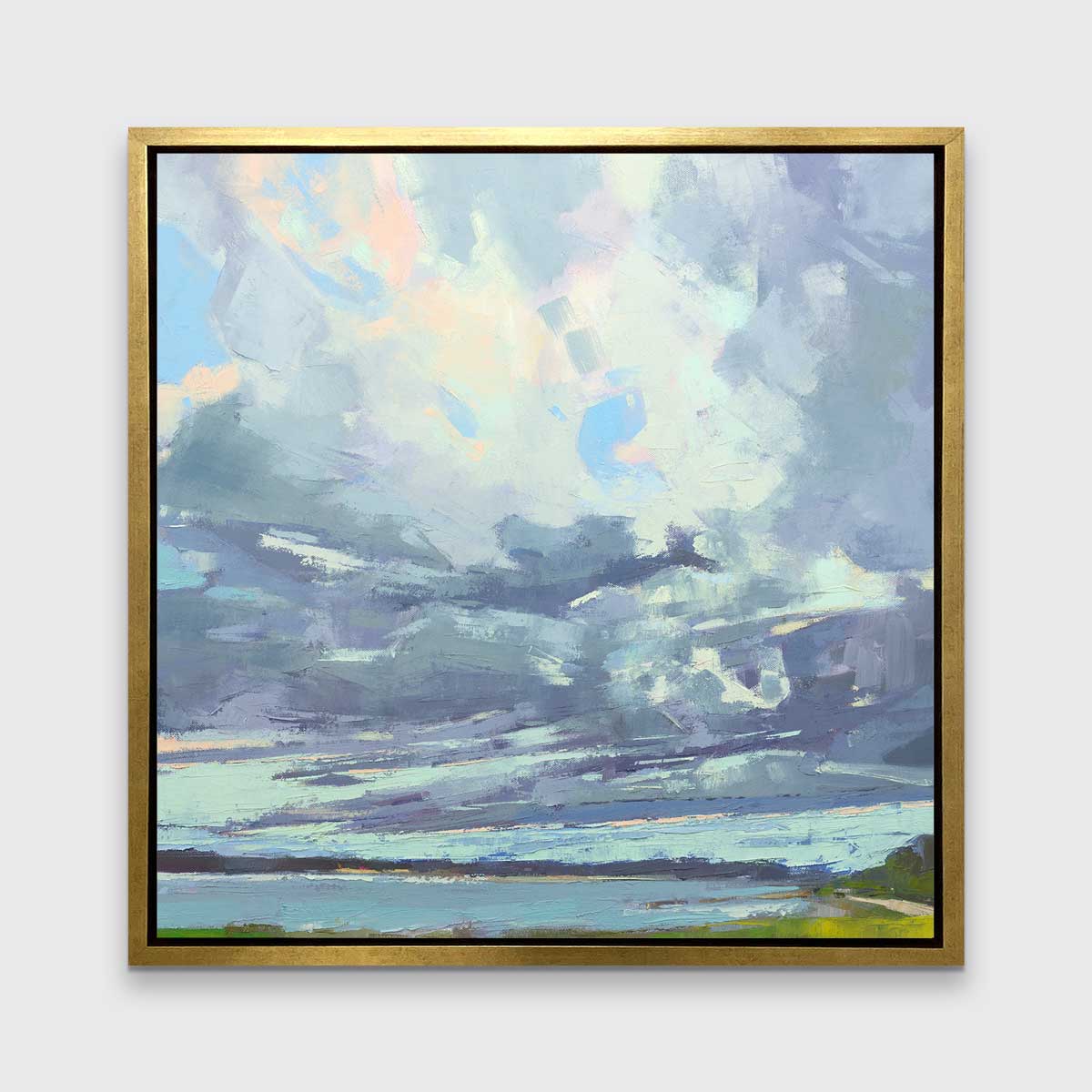 A blue, white and green abstract landscape print in a gold floater frame hangs on a white wall.