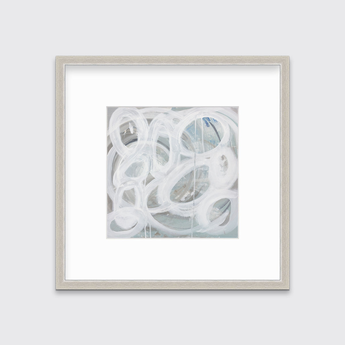 A white, light teal and grey abstract print in a silver frame with a mat hangs on a white wall.