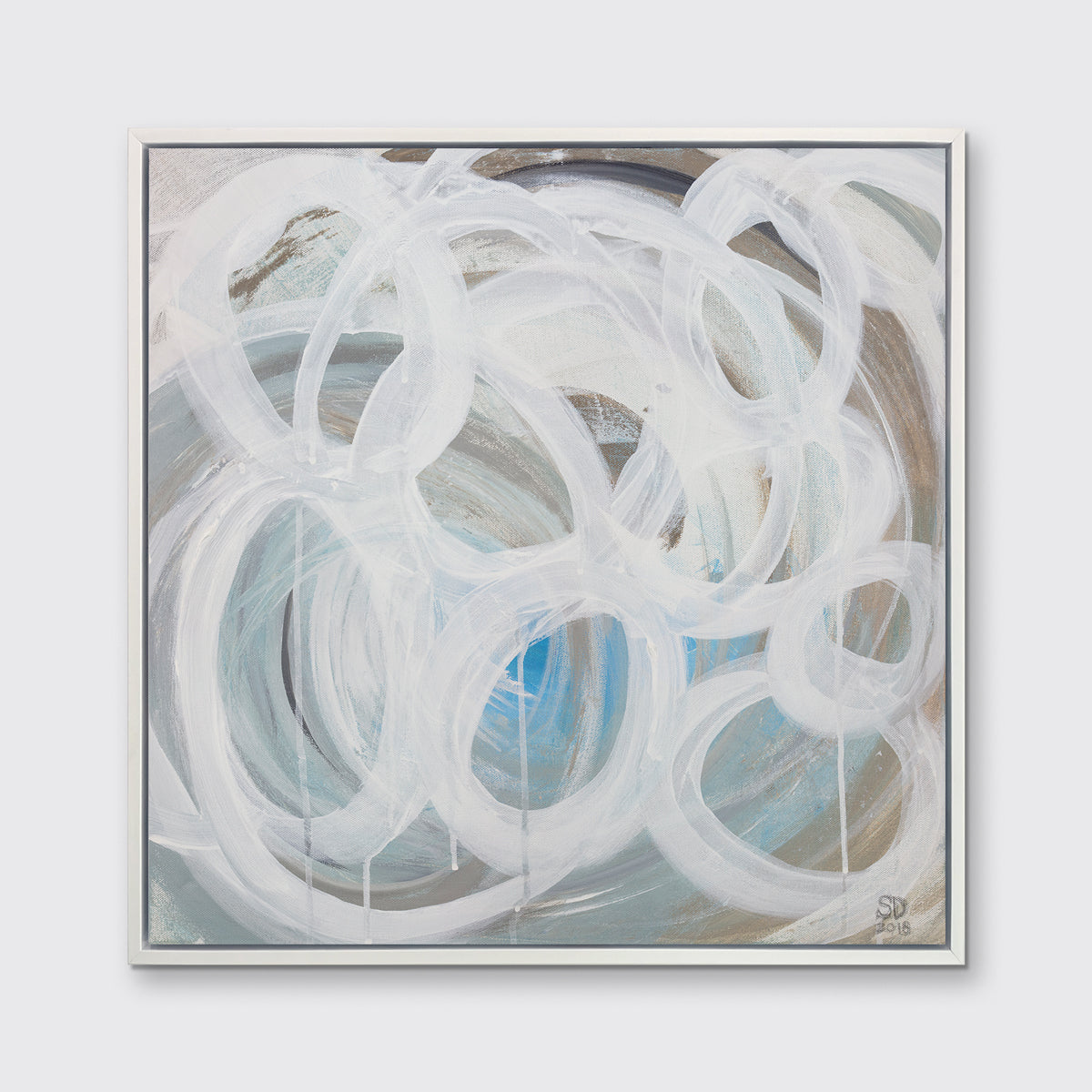 A white, light teal, blue and beige abstract print in a white floater frame hangs on a white wall.