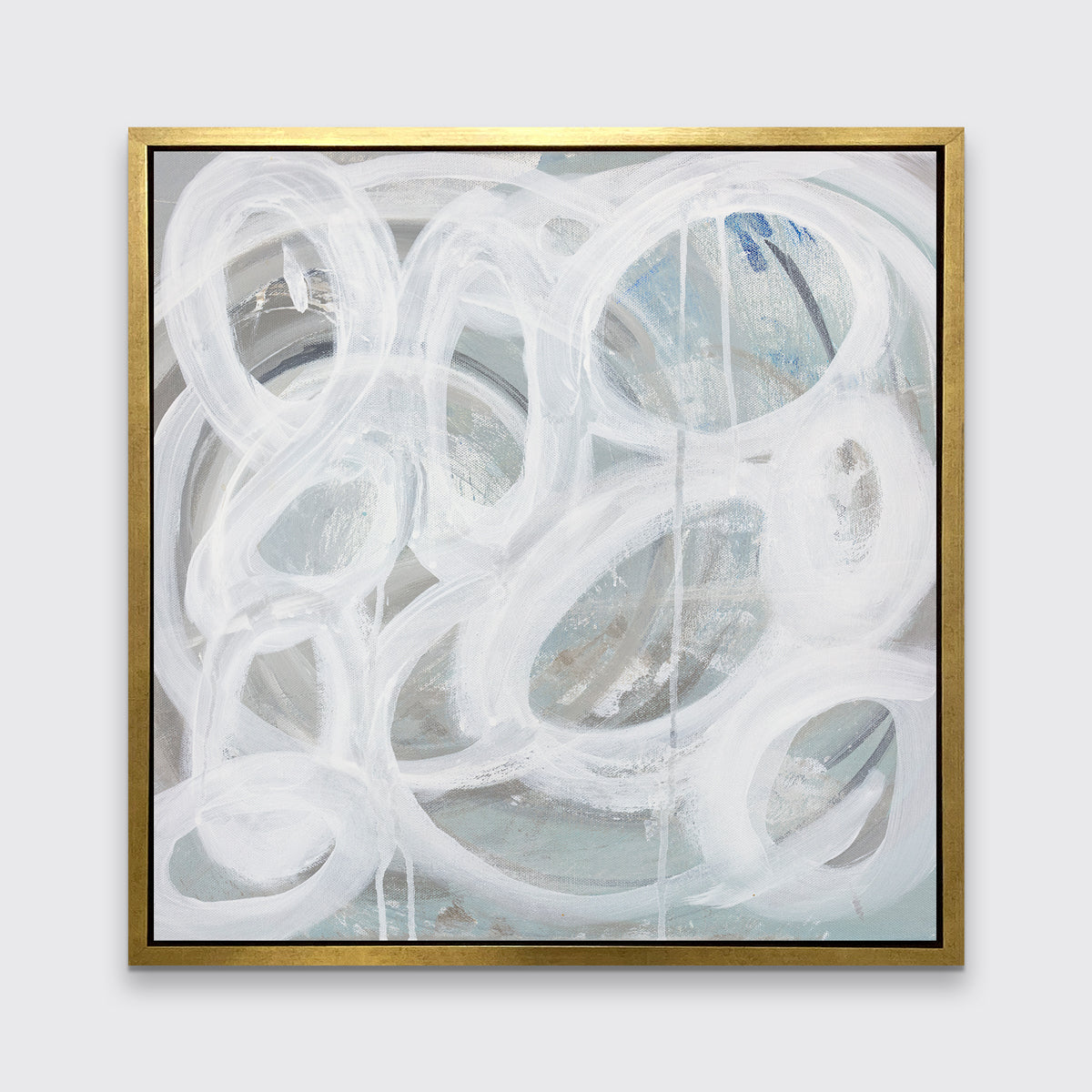 A white, light teal and grey abstract print in a gold floater frame hangs on a white wall.