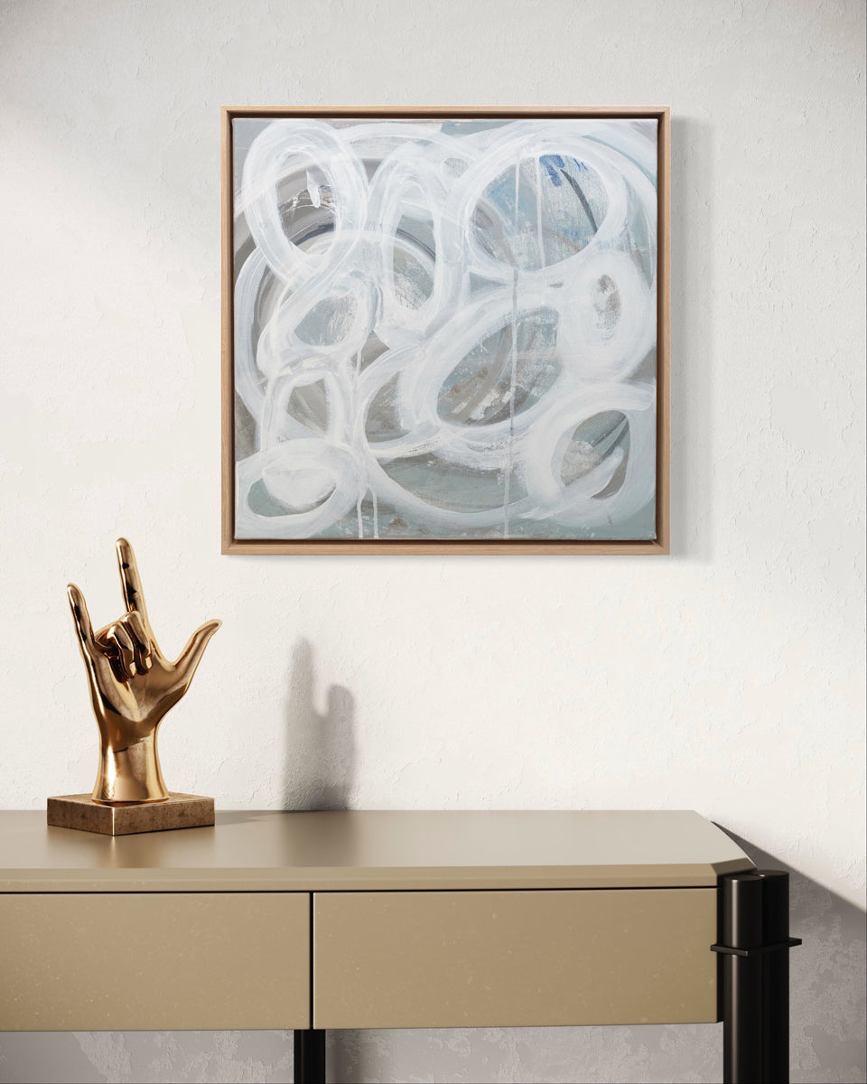 A slate grey canvas painting with white concentric circles hangs above a desk. Wired and ready to hang.