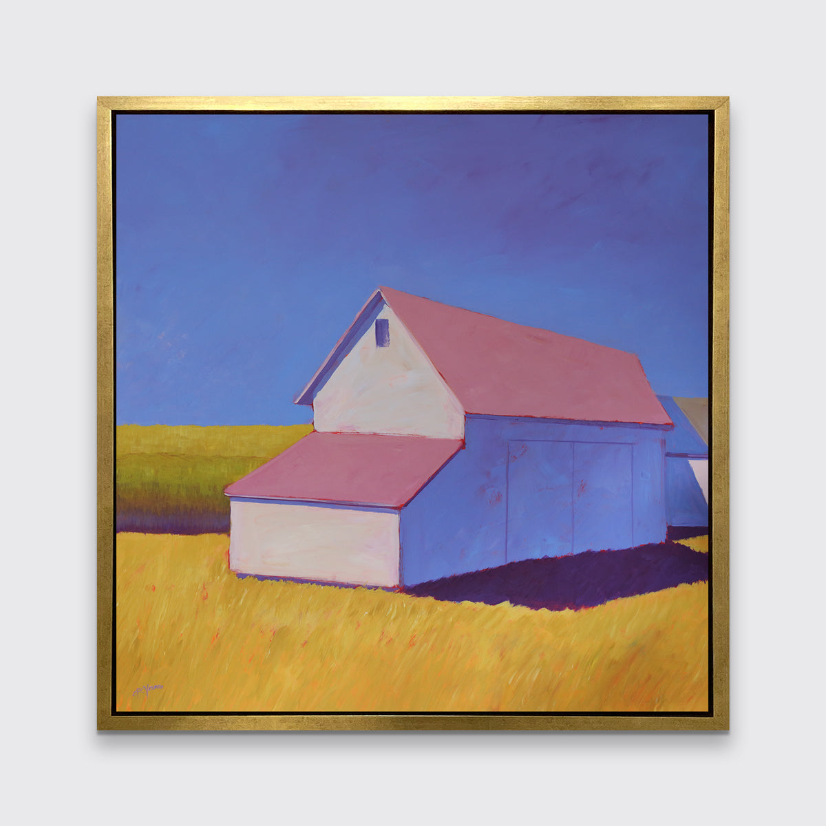 A white barn with a pink roof and yellow grass print in a gold floater frame hangs on a white wall.