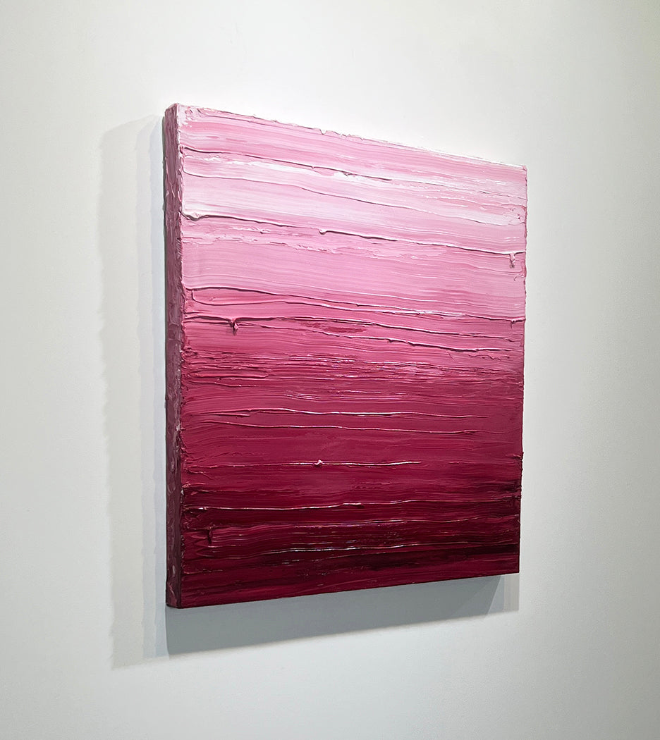 A left side-view of a pink, raspberry and white toned textured painting by Teodora Guererra hangs on a white wall.