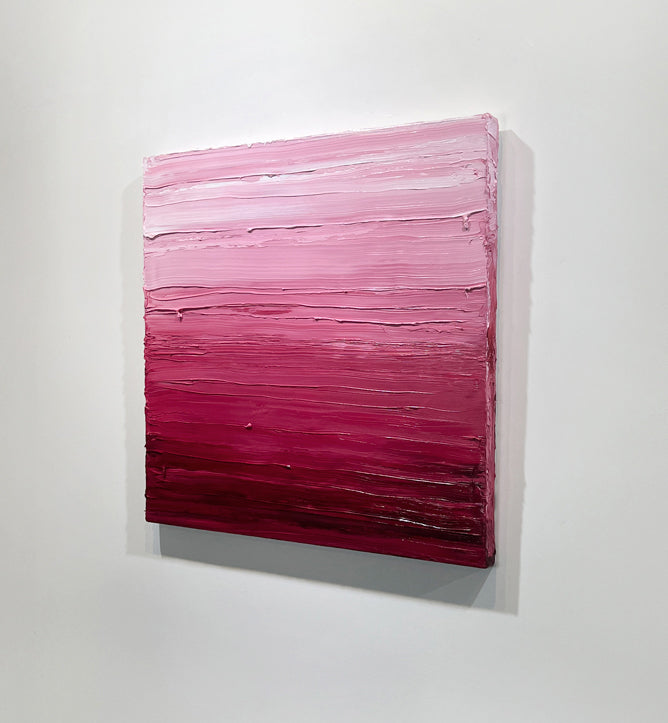 A right side-view of a pink, raspberry and white toned textured painting by Teodora Guererra hangs on a white wall.