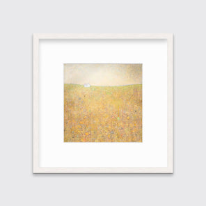 A yellow and grey abstract landscape print in a whitewashed frame with a mat hangs on a white wall.