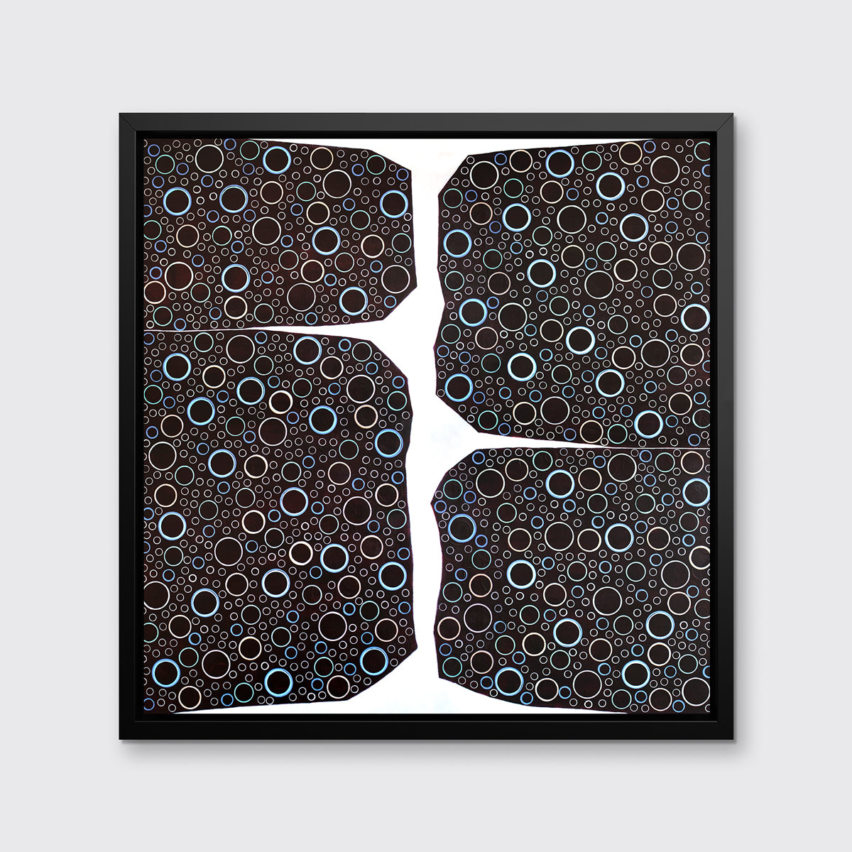 A multicolored abstract print in a black floater frame hangs on a white wall.