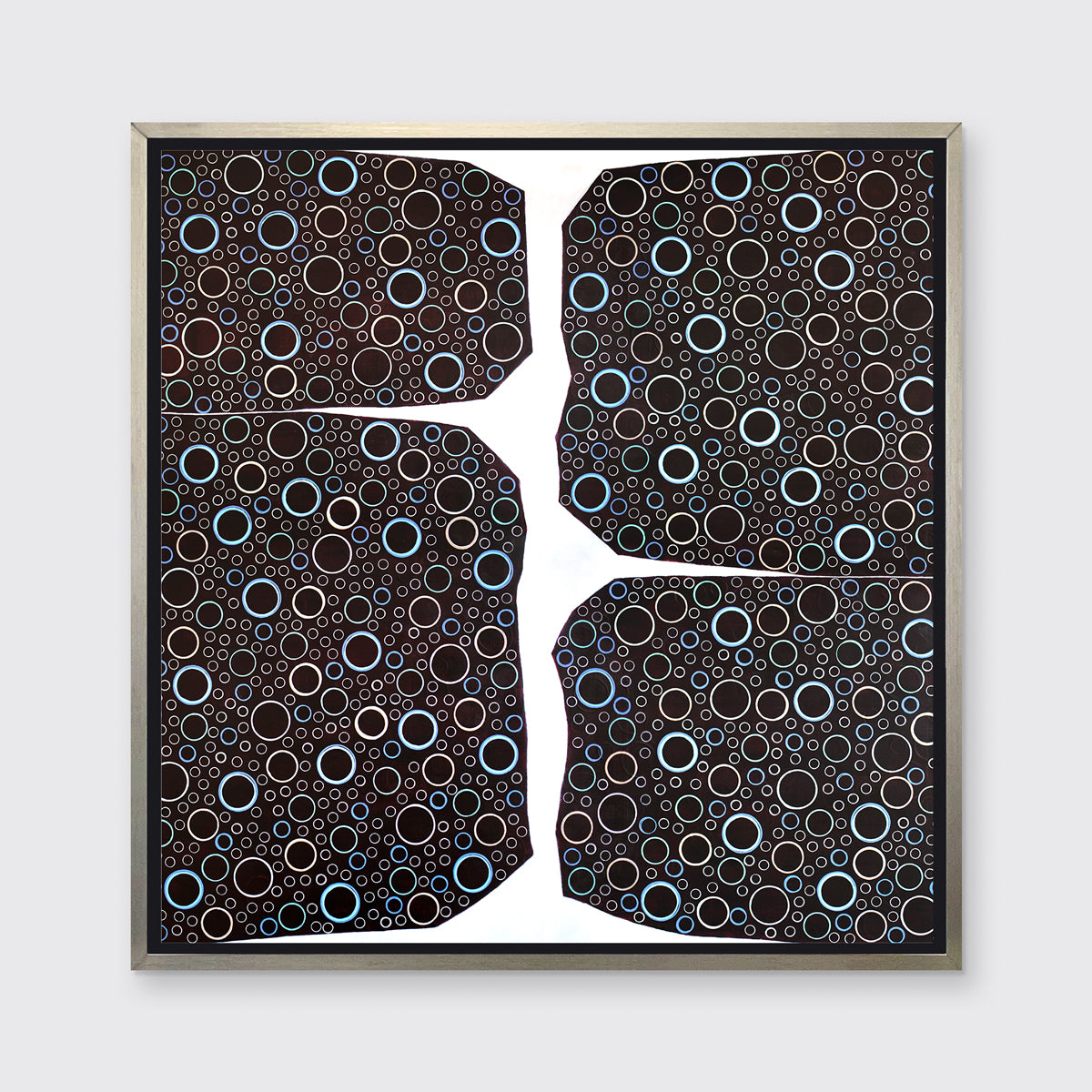 A multicolored abstract print in a silver floater frame hangs on a white wall.
