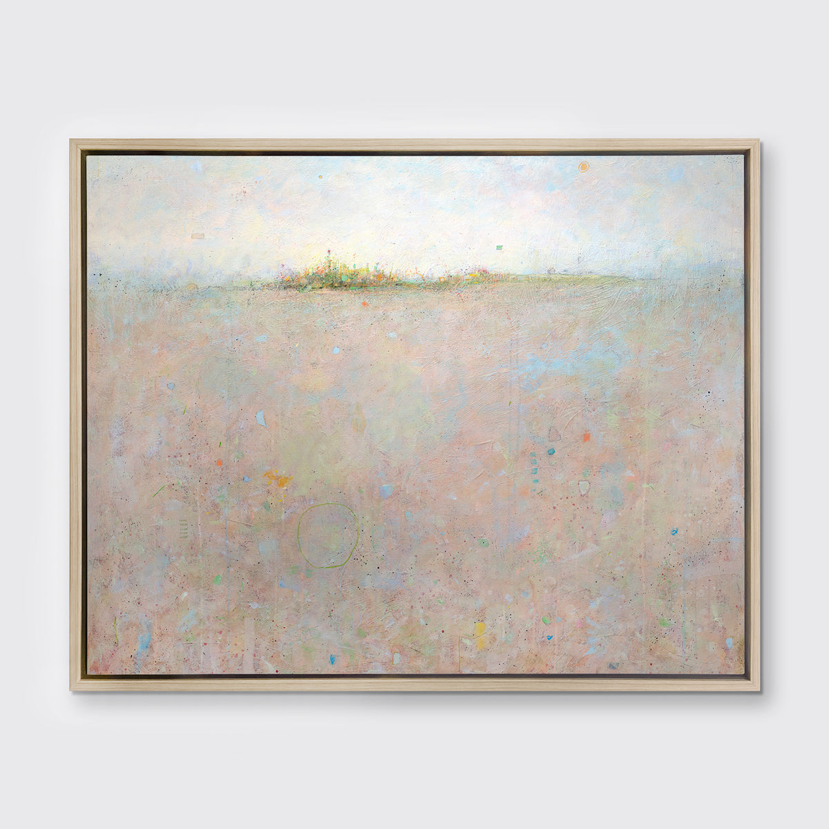 A peach and blue abstract landscape print in a white oak wood floater frame hangs on a white wall.