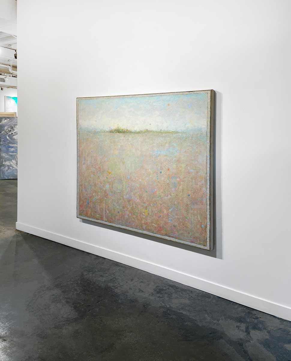 A right side-angle of a peach colored abstract landscape hangs on a white wall.