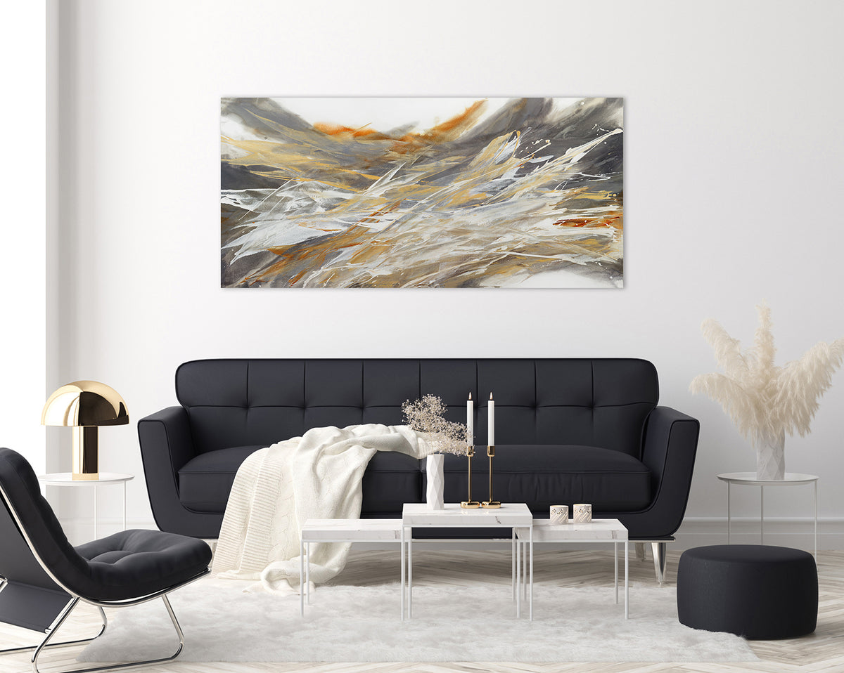 An orange, white, and grey abstract painting by Teodora Guererra hangs on a white wall above a dark grey couch and a white coffee table. 