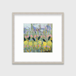 A green, yellow and pink abstract floral print in a silver frame with a mat hangs on a white wall.