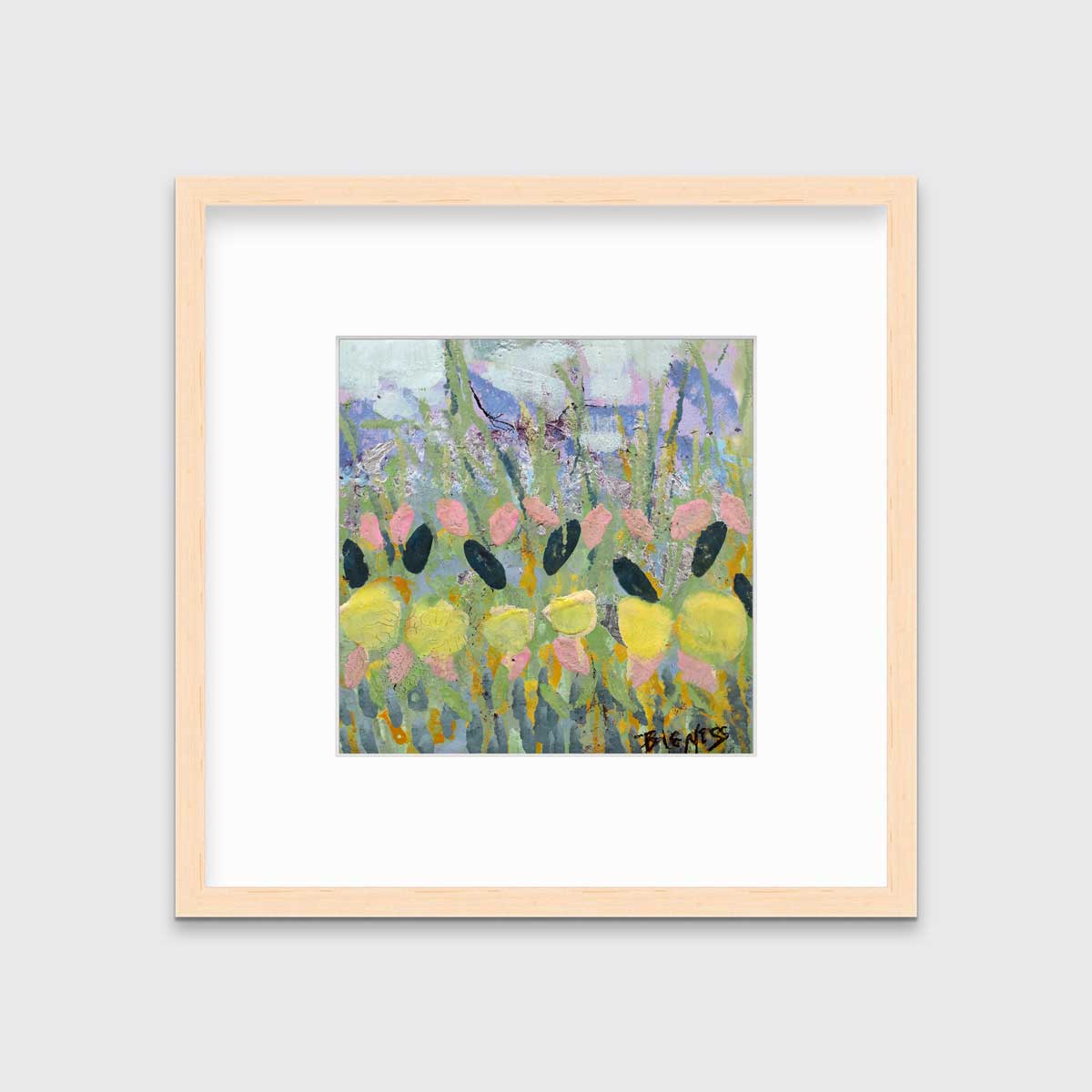 A green, yellow and pink abstract floral print in a natural wood frame with a mat hangs on a white wall.
