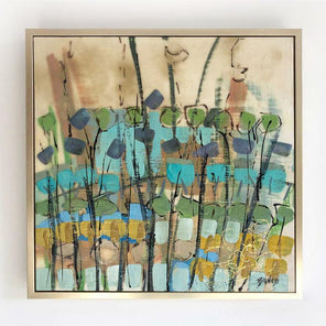 A straight-on view of an abstract encaustic painting featuring green, blue, and earth tones, and framed in a gold frame hanging on a white wall.