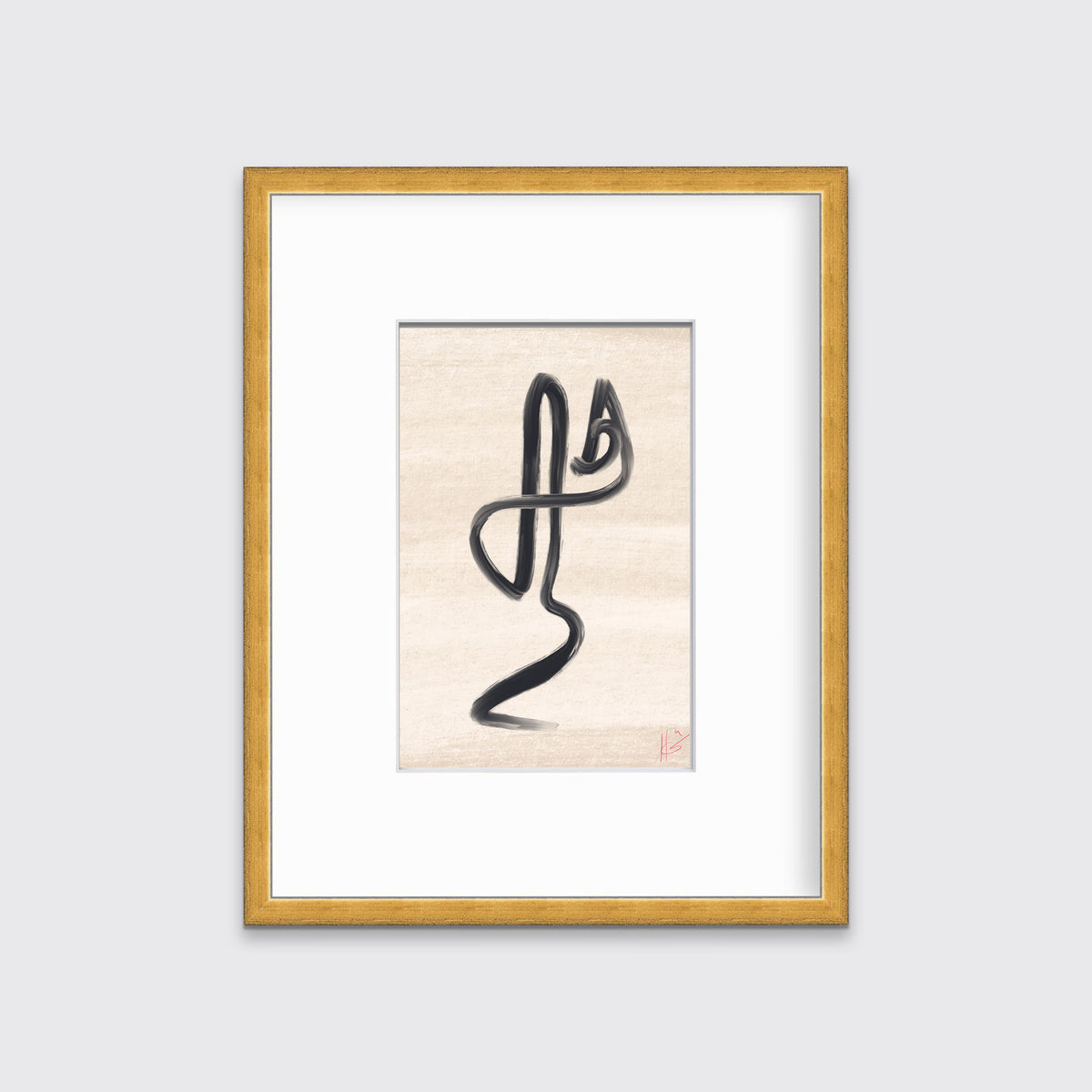 An abstract black and beige art print framed in a gold frame hangs on a light grey wall. 