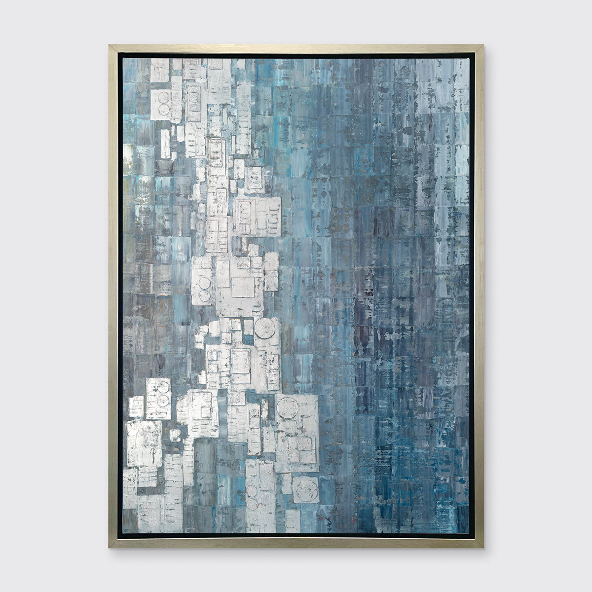 A blue, white and grey abstract print in a silver floater frame hangs on a white wall.