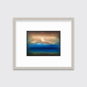 A dark brown, blue, white and teal abstract landscape print in a silver frame with a mat hangs on a white wall.