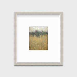 A dark yellow, green and beige abstract landscape print in a silver frame with a mat hangs on a white wall.