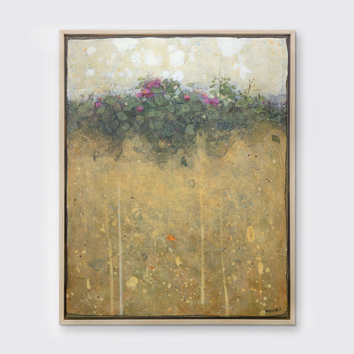 A dark yellow, green and beige abstract landscape print in a white oak wood floater frame hangs on a white wall.