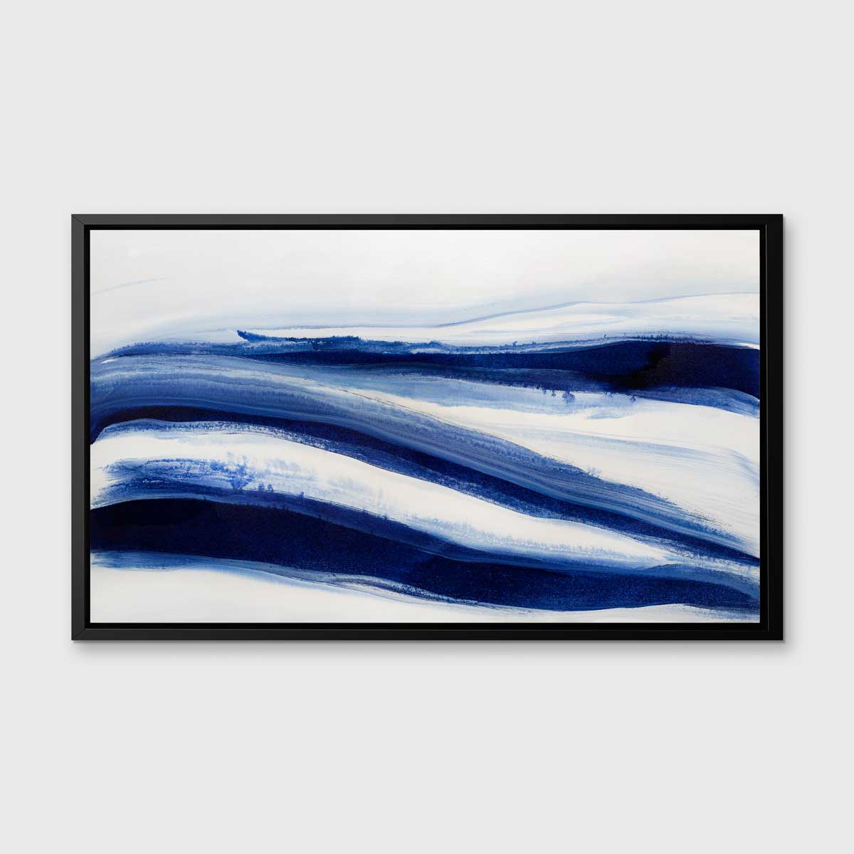 A dark blue and white abstract print in a black floater frame hangs on a white wall.