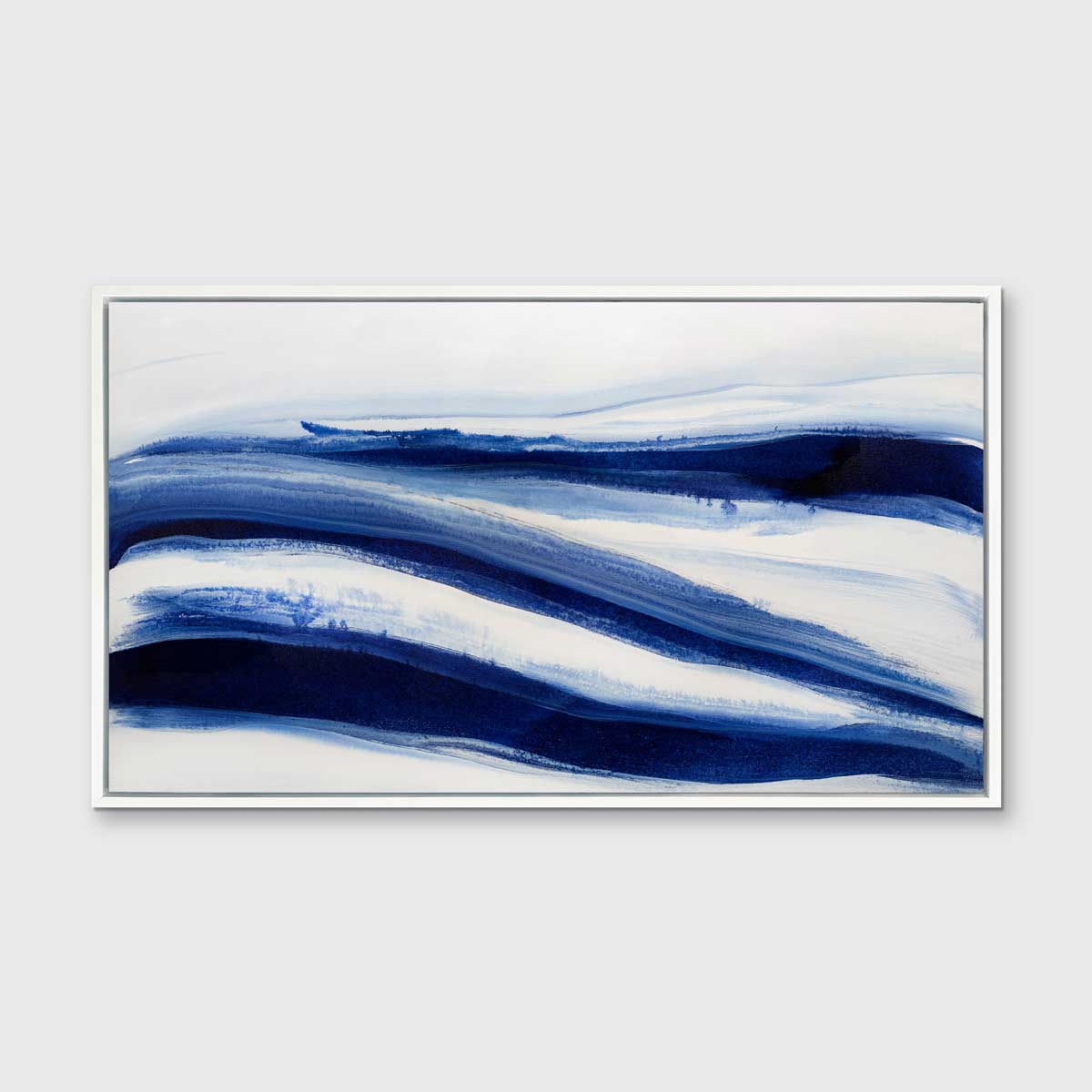 A dark blue and white abstract print in a white floater frame hangs on a white wall.