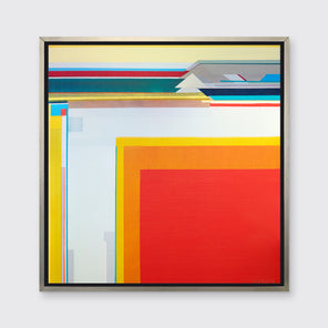 A yellow, red and white geometric abstract print in a silver floater frame hangs on a white wall.