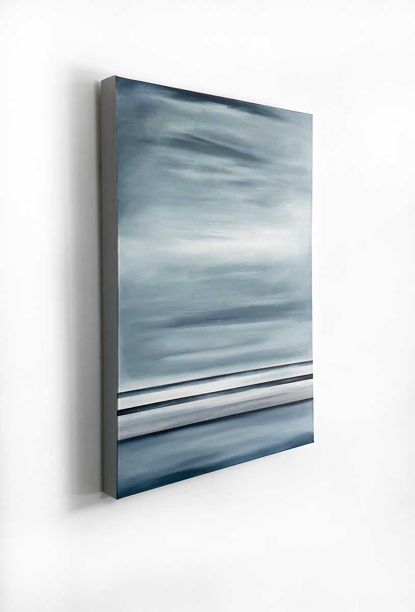 A left side-angle view of a blue-grey abstract painting hanging on a white wall.