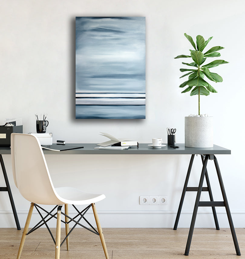An abstract blue-grey painting hangs on a white wall above a modern minimalist office desk, chair, office supplies and potted plant.