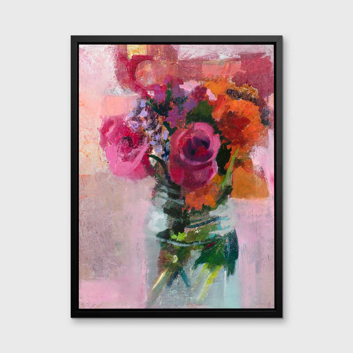 A pink, orange and green abstract floral print in a black floater frame hangs on a white wall.