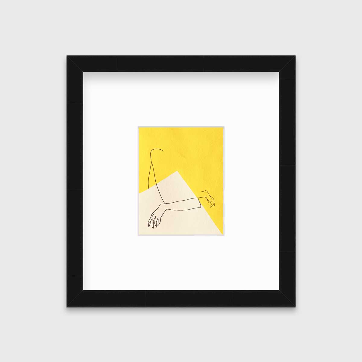 A yellow and white abstract print by Hazal Ozturk in a black frame with a mat hangs on a white wall.