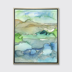 A green and blue landscape illustration print framed in a warm silver floater frame hangs on a light grey wall.