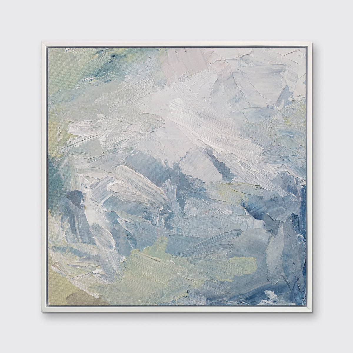 A white, blue, grey and light green abstract print in a white floater frame hangs on a white wall.
