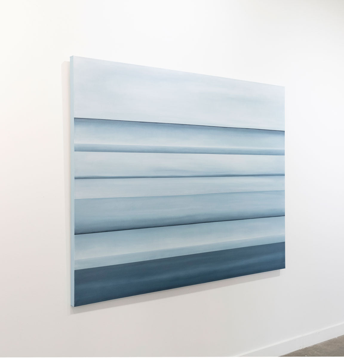 A blue oil painting with multiple navy lines running horizontally on the canvas that suggest horizon lines is seen at an angle on a gallery wall. Wired and ready to hang.