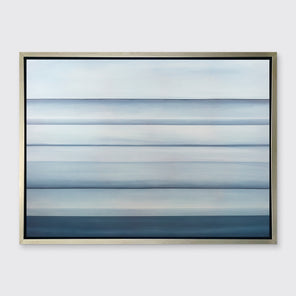 A tonal blue abstract landscape print in a silver floater frame hangs on a white wall.